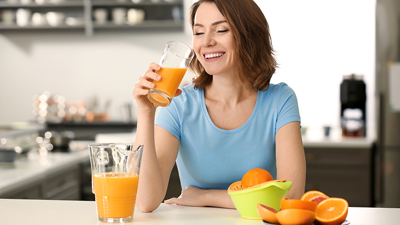 mujer consumiendo zumo de naranja